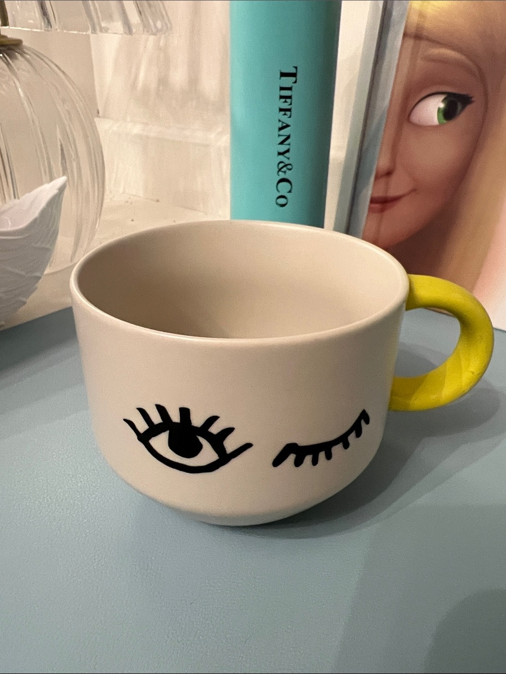 Starbucks White Mug with Black Eye Graphic and Yellow Handle